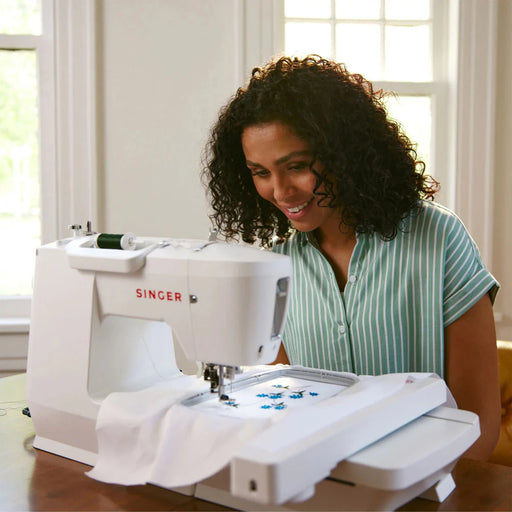 SINGER SE9180 embroidery machine in use creating detailed embroidery design on fabric with large embroidery hoop attached