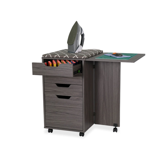 Arrow Sewing Kiwi Storage Cabinet used as an ironing station with iron placed on padded cover, open thread drawer, and fold-out cutting table extension.