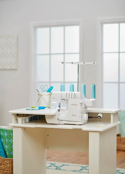 Baby Lock Acclaim BLES4 serger placed in sewing workstation table, ready for serging projects with teal thread cones.