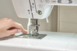 Close-up of Baby Lock Allegro sewing machine needle area with user threading and built-in needle threader.