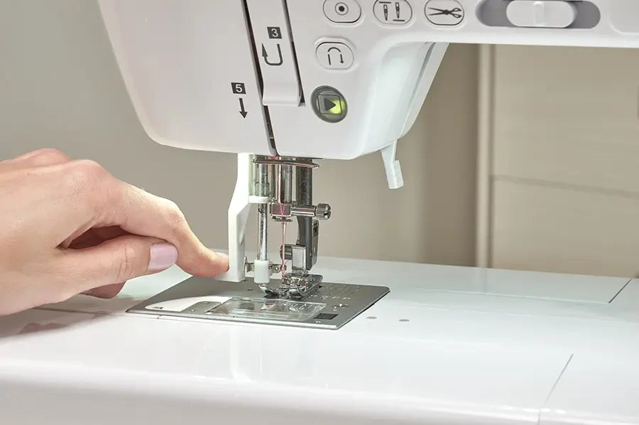 Close-up of Baby Lock Allegro sewing machine needle area with user threading and built-in needle threader.