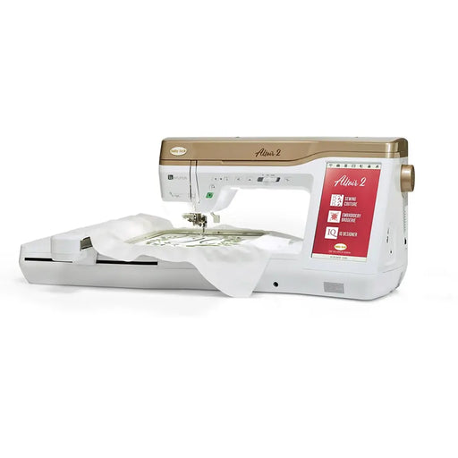 Baby Lock Altair 2 BLTA2 embroidery and sewing machine with extended embroidery arm stitching a detailed green monogram pattern.