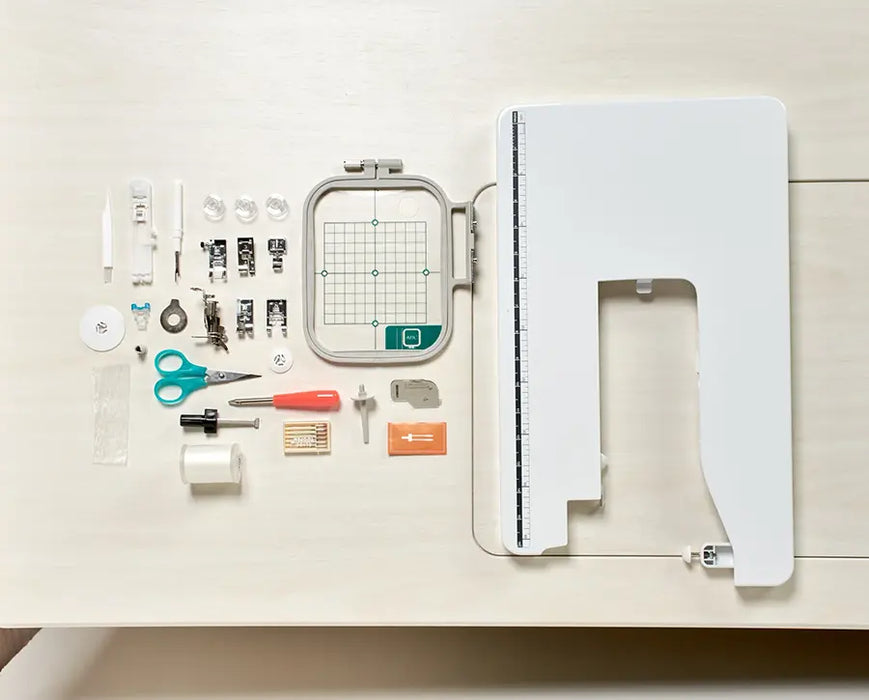 Baby Lock Aurora BLMAR sewing machine accessories laid out, including presser feet, 4x4 embroidery hoop, extension table, bobbins, scissors, and tools.