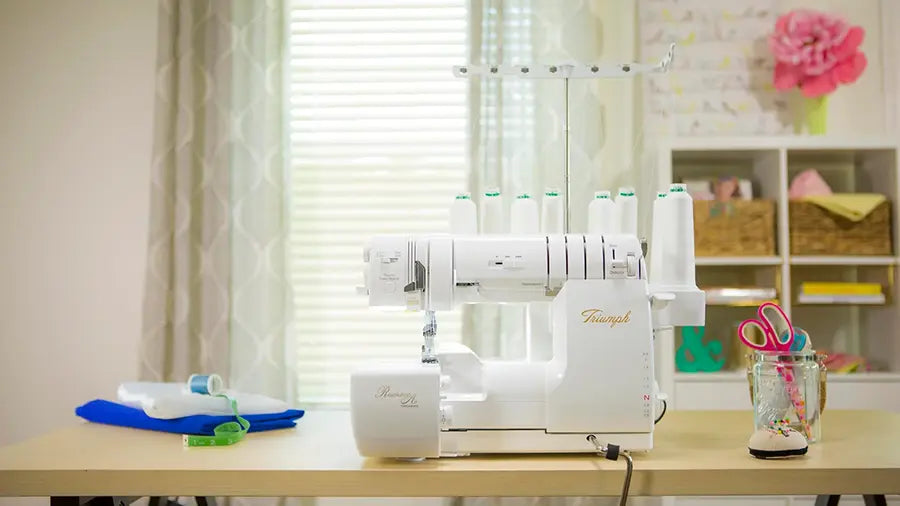 Baby Lock Triumph 50th Anniversary Edition serger set up in a sewing studio, demonstrating workspace integration and multi-thread functionality.