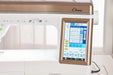 Close-up of Baby Lock Chorus quilt and sewing machine touchscreen displaying built-in stitches and digital settings