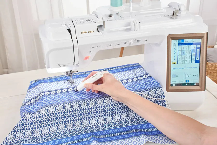 Baby Lock Chorus sewing machine using Sensor Pen to set stitch placement on patterned blue fabric