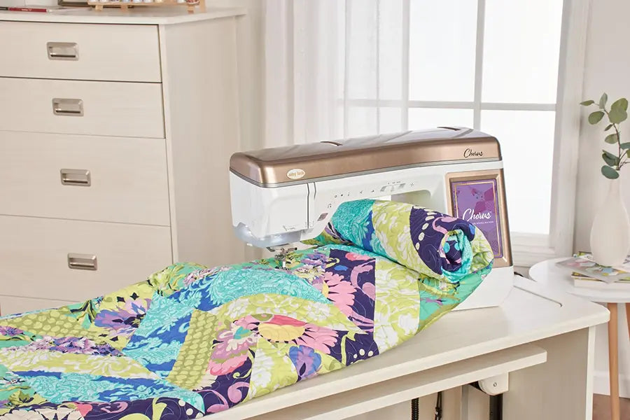 Baby Lock Chorus quilting and sewing machine handling a colorful quilt with its large 11.25-inch workspace