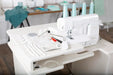 Baby Lock Euphoria BLC4 Cover Stitch Machine displayed in sewing workstation with included accessories and tools.