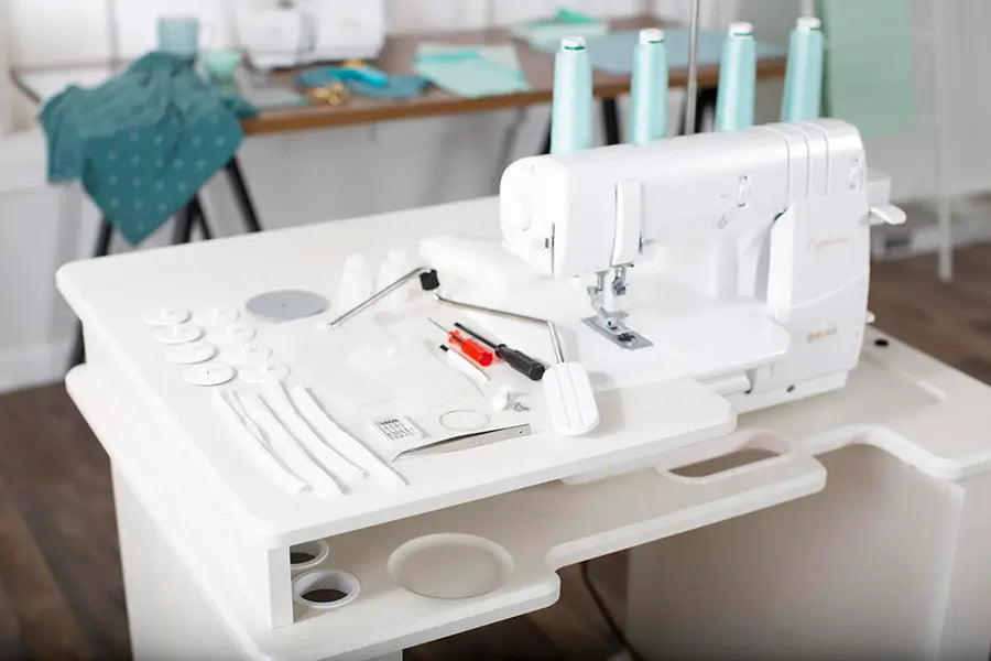 Baby Lock Euphoria BLC4 Cover Stitch Machine displayed in sewing workstation with included accessories and tools.