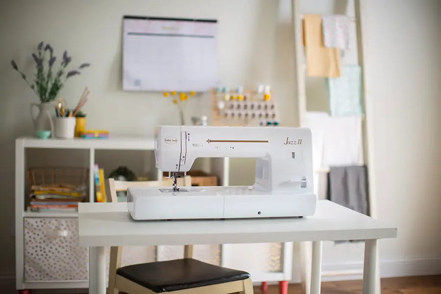 Front view of Baby Lock Jazz II quilting and sewing machine positioned in a home sewing studio setup.
