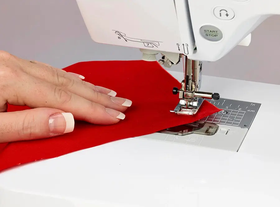 Close-up of Baby Lock Soprano BLMSP presser foot quilting a red fabric piece on the sewing machine