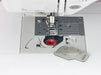 Top-loading bobbin area of Baby Lock Soprano BLMSP sewing and quilting machine with clear cover and red bobbin thread