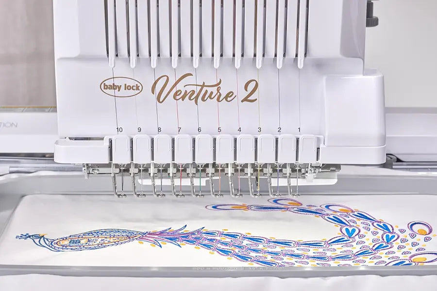 Close-up of Baby Lock Venture 2 needle system stitching a detailed multicolor embroidery design.