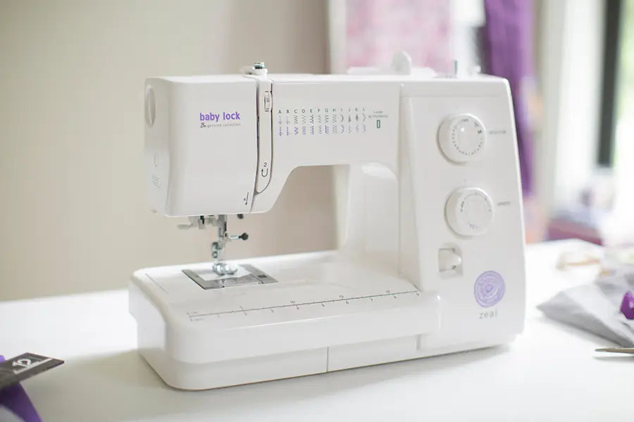 Baby Lock Zeal Mechanical Sewing Machine on crafting table with natural light, showcasing beginner-friendly features.