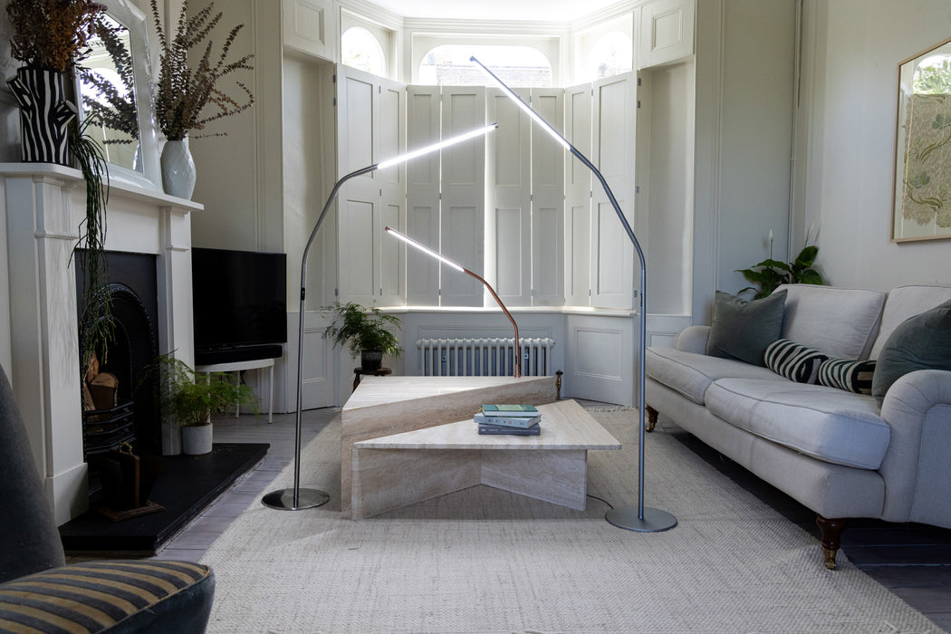 Daylight Slimline 4 LED floor lamps in brushed steel and bronze finishes displayed in a modern living room, highlighting slim profile and contemporary task lighting design.