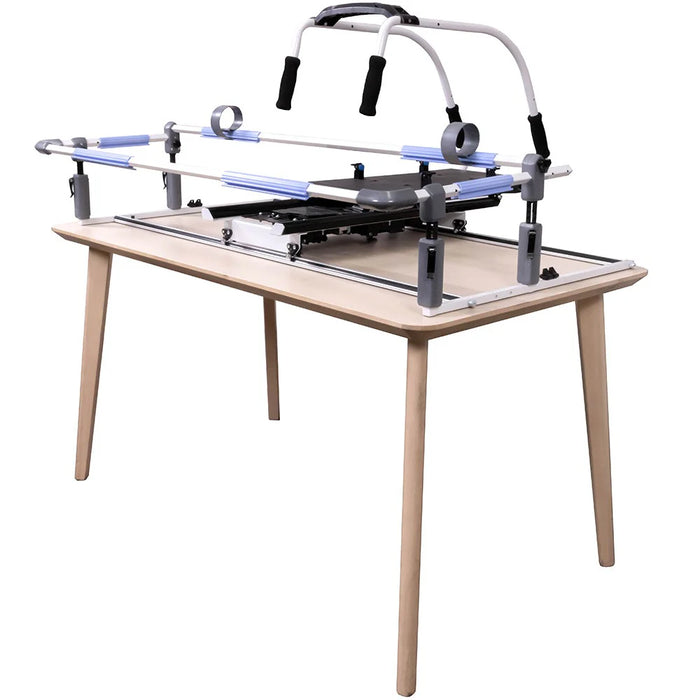 Portable Grace Cutie Breeze quilting frame setup on a table with front-mounted handles