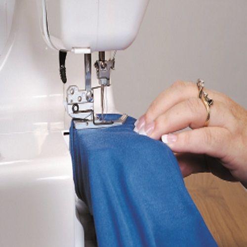 Sewing fabric on the Janome CoverPro 900CPX coverstitch machine, demonstrating smooth hemming and precision stitch performance.