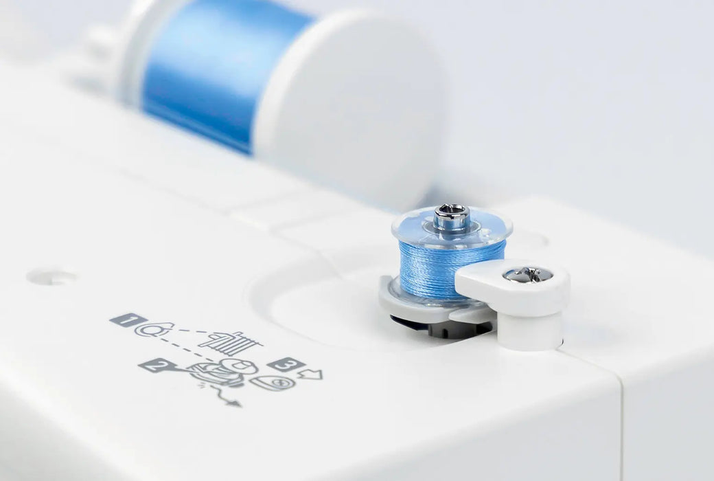 Close-up of Janome MC1000 bobbin winding system with blue thread for sewing and embroidery projects