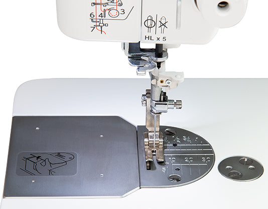 Close-up of Janome HD9V2 needle area, stainless-steel needle plate, and precision stitch markings for accurate sewing.
