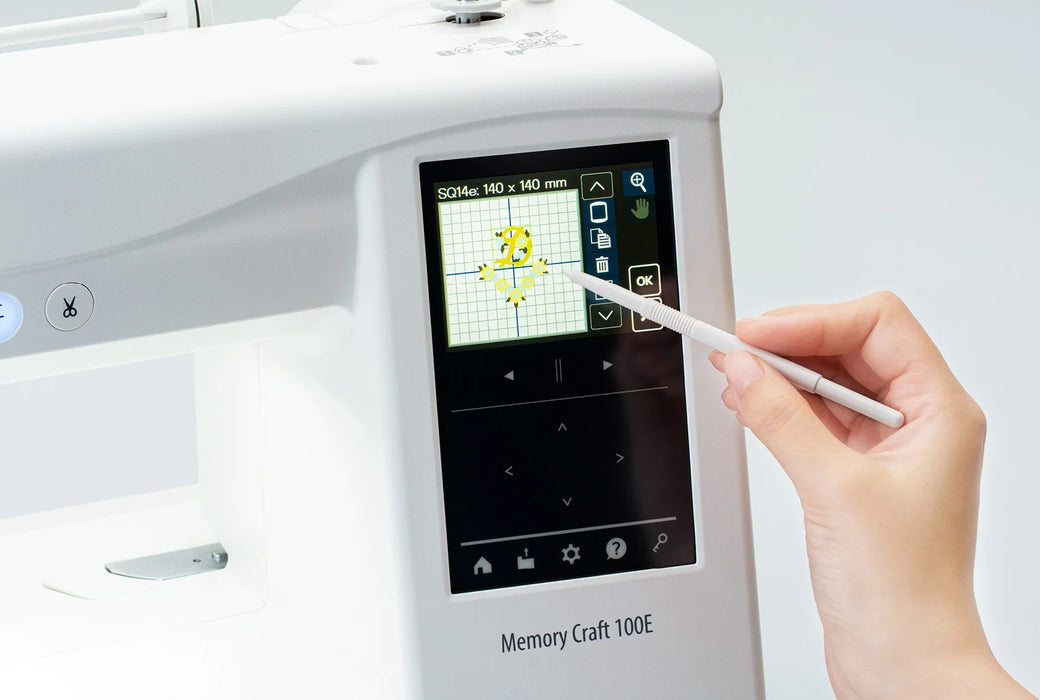 Close-up of Janome Memory Craft 100E LCD touchscreen showing embroidery design editing with stylus for precision control.