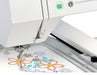 Close-up of Janome MC550E Limited Edition needle area stitching colorful floral embroidery design with precision.