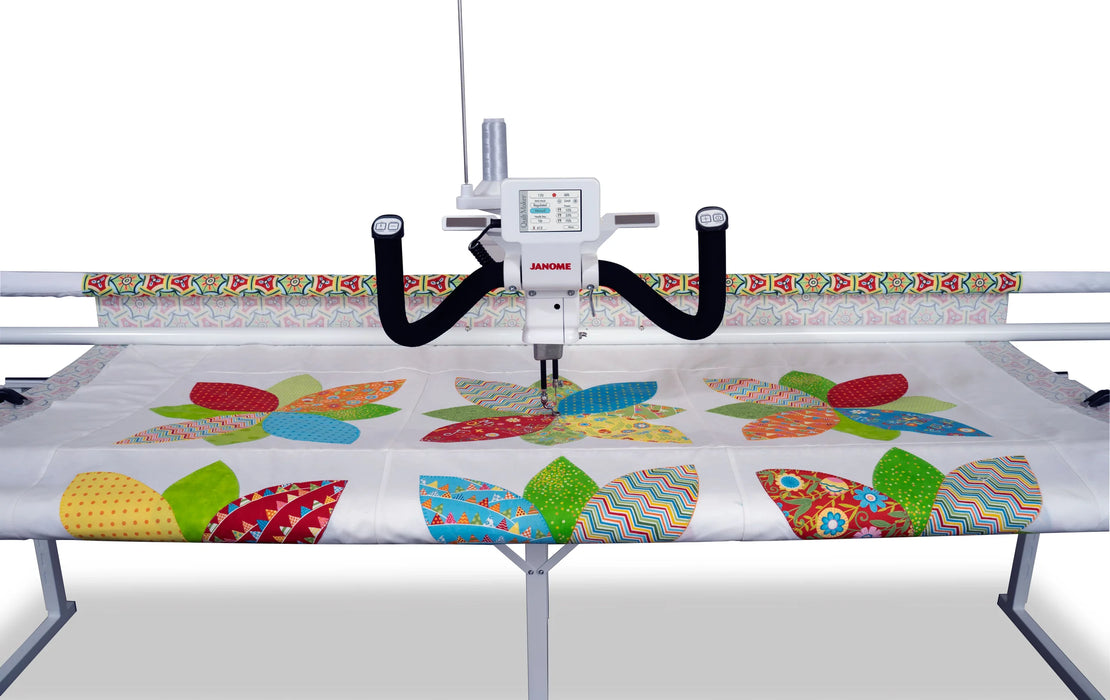 Janome Quilt Maker 18 long arm quilting machine actively quilting a patterned fabric, highlighting stitch accuracy and large work area
