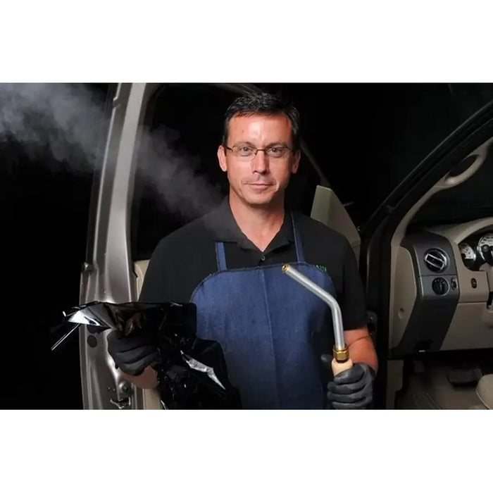 Close-up of automotive window tint lifting away from glass as SteamBlade steam loosens adhesive