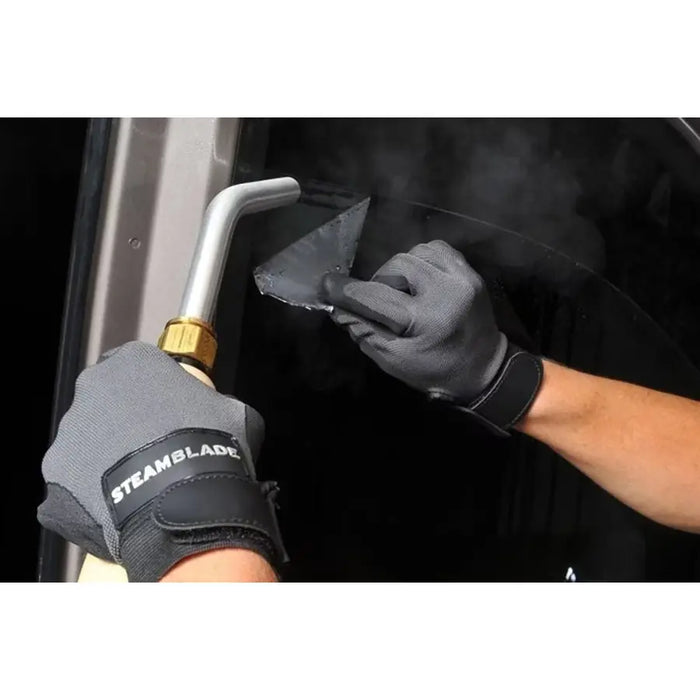Technician using the Jiffy SteamBlade to lift and remove automotive window tint with targeted steam