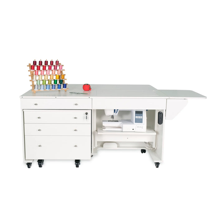 White electric lift sewing cabinet with sewing machine lowered and storage drawers on caster wheels