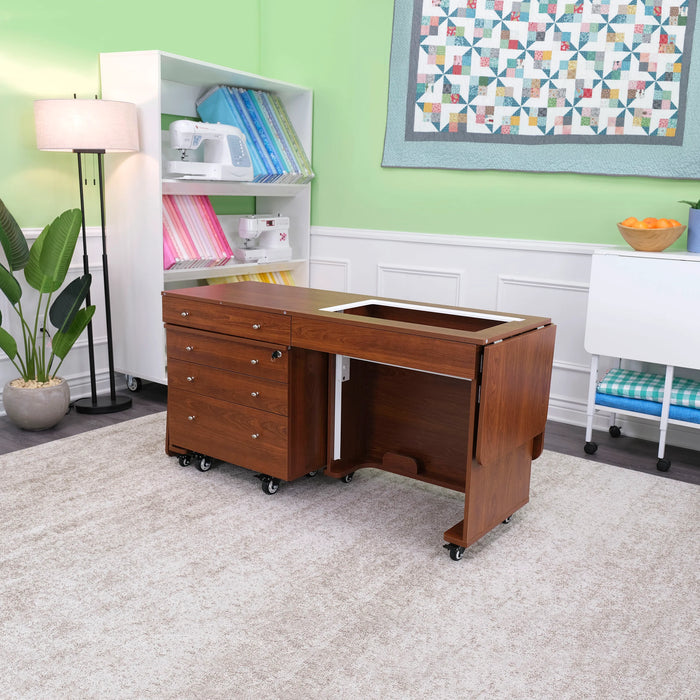 Kangaroo & Joey Sewing Cabinet folded into compact position with Joey storage caddy nested underneath, shown in modern sewing and crafting room.