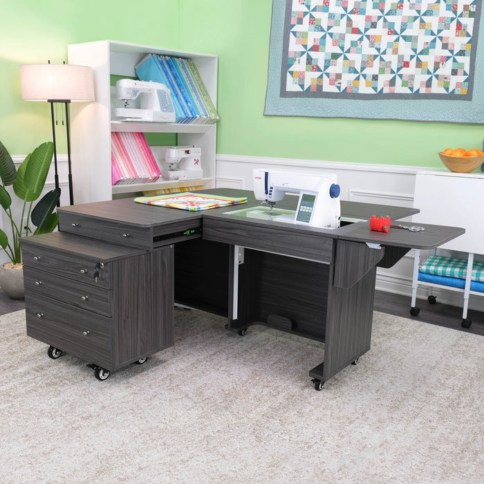 Kangaroo & Joey gray sewing cabinet set up in craft room, showing expansive quilting workspace, drawer storage, and ergonomic sewing machine positioning.