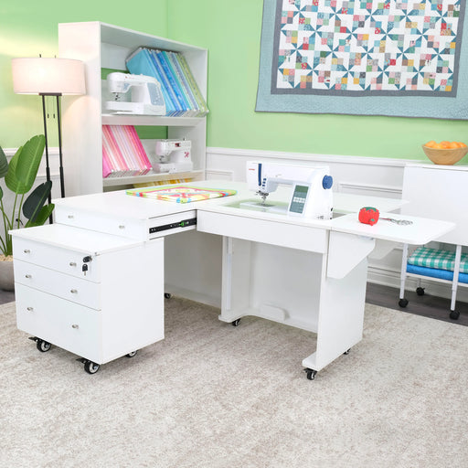 White Kangaroo & Joey Sewing Cabinet set up in craft room showing expanded work surface, sewing machine platform, and mobile storage drawers.