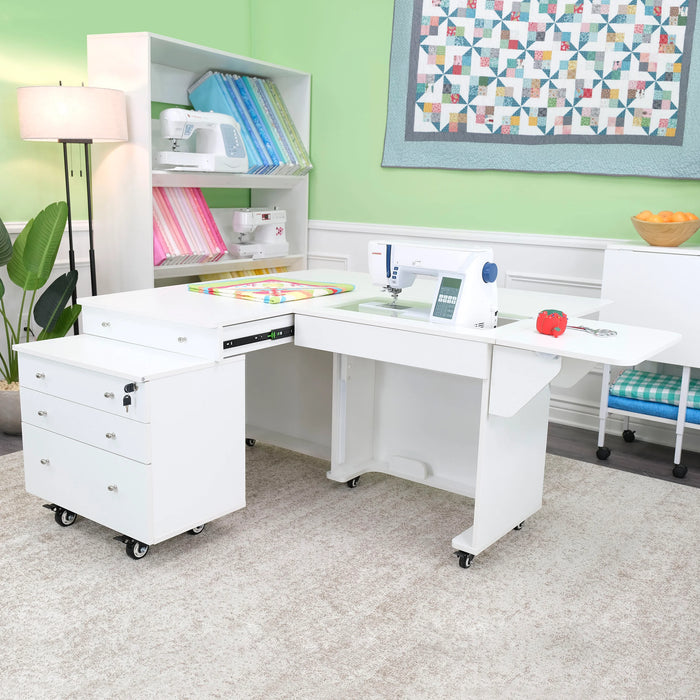 White Kangaroo & Joey Sewing Cabinet set up in craft room showing expanded work surface, sewing machine platform, and mobile storage drawers.