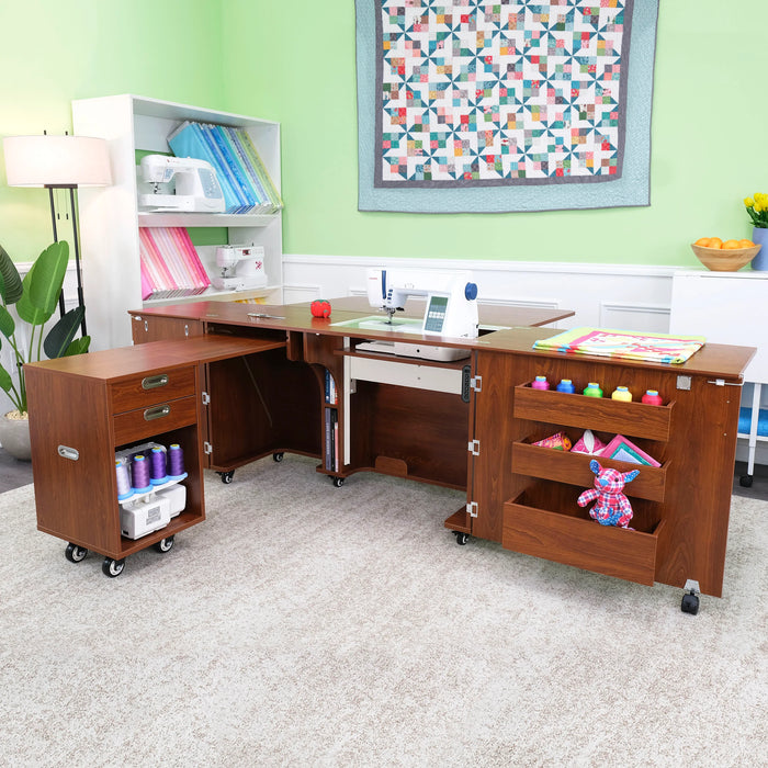 Aussie Dual Rail Electric Sewing Cabinet in Teak shown in creative sewing room setup with expanded work surface and rolling storage caddy