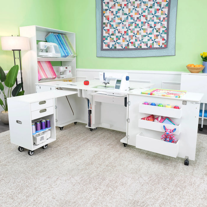 Kangaroo Aussie Sewing Cabinet K8611EL in White set up in a sewing room, featuring electric lift, rolling caddy, and extended quilting surface.