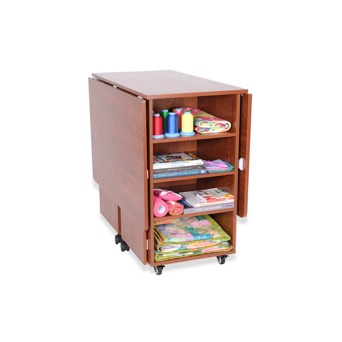 Kangaroo Kookaburra Cutting Table folded into compact position showcasing rear storage shelves for fabric, books, and sewing notions.