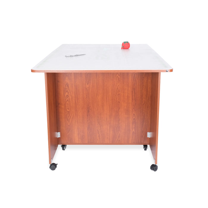 Rear view of the Kangaroo Kookaburra Cutting Table in teak finish, highlighting the solid back panel and sturdy caster wheels.