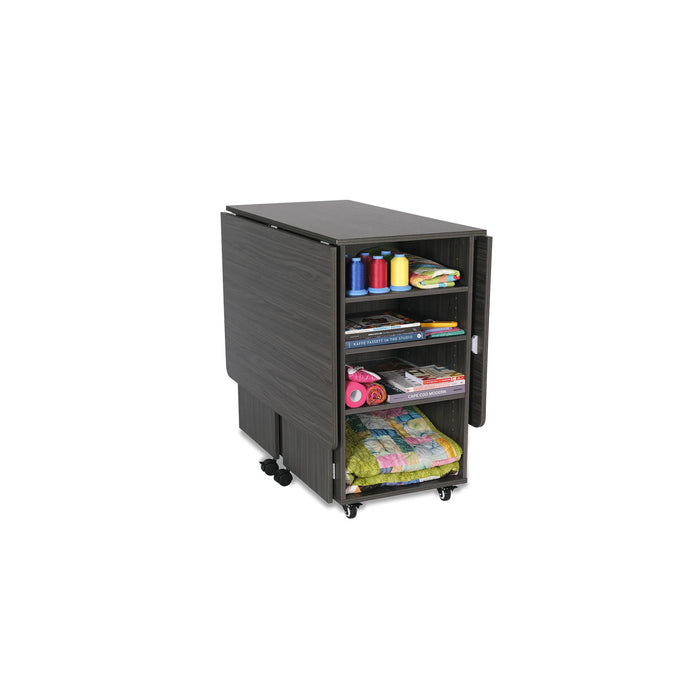 Kangaroo Kookaburra Cutting Table in gray finish folded into compact position with visible storage shelves for fabric, books, and sewing notions.