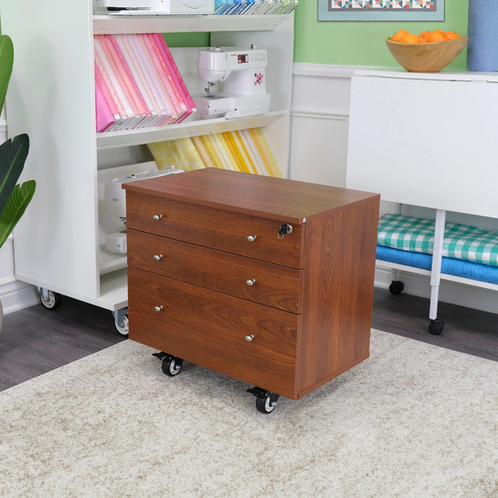 Kangaroo Joey Storage Cabinet in Teak K7805 placed in a sewing room setup, showcasing mobile craft storage with warm teak wood finish.