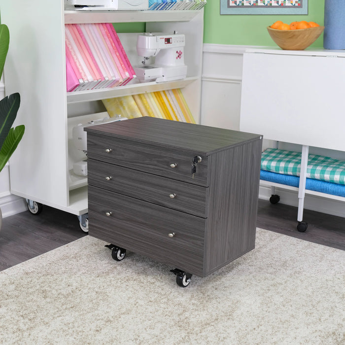 Gray Kangaroo Joey Storage Cabinet K7807 displayed in a sewing room setup, offering mobile craft storage on durable casters.