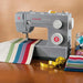 SINGER 4432 Heavy Duty sewing machine in use sewing colorful fabric on tabletop workspace