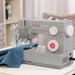 SINGER Heavy Duty 4452 sewing machine sewing fabric on tabletop, demonstrating smooth operation and precision stitching