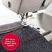 Close-up of SINGER Heavy Duty 6700C needle and presser foot sewing multiple layers of thick denim fabric