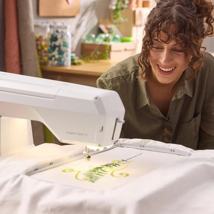 Sewist using Husqvarna Viking Designer Topaz 65 embroidery machine in a home sewing studio environment